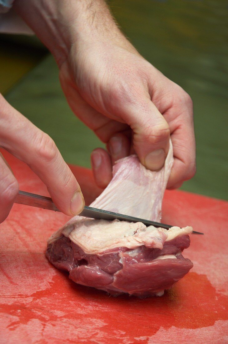 The skin being removed from a piece of meat