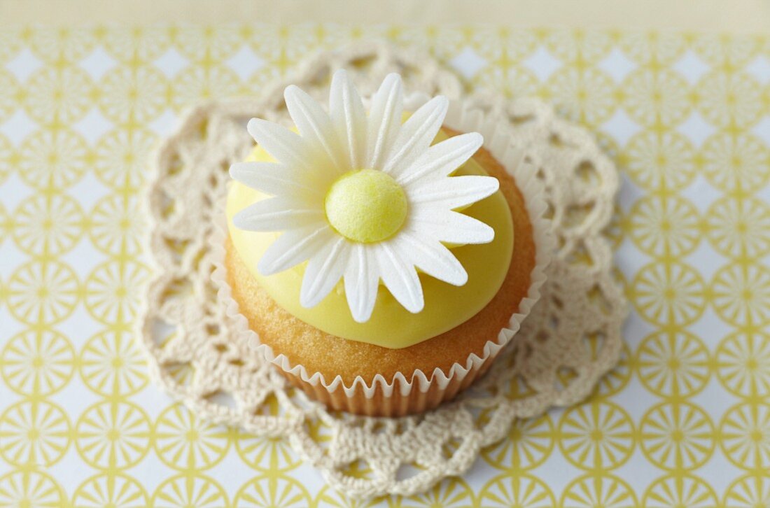 Cupcake mit Margerite auf Spitzendeckchen