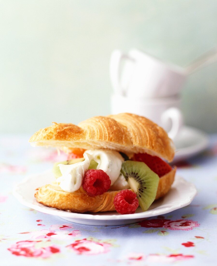 A croissant filled with fruits and cream