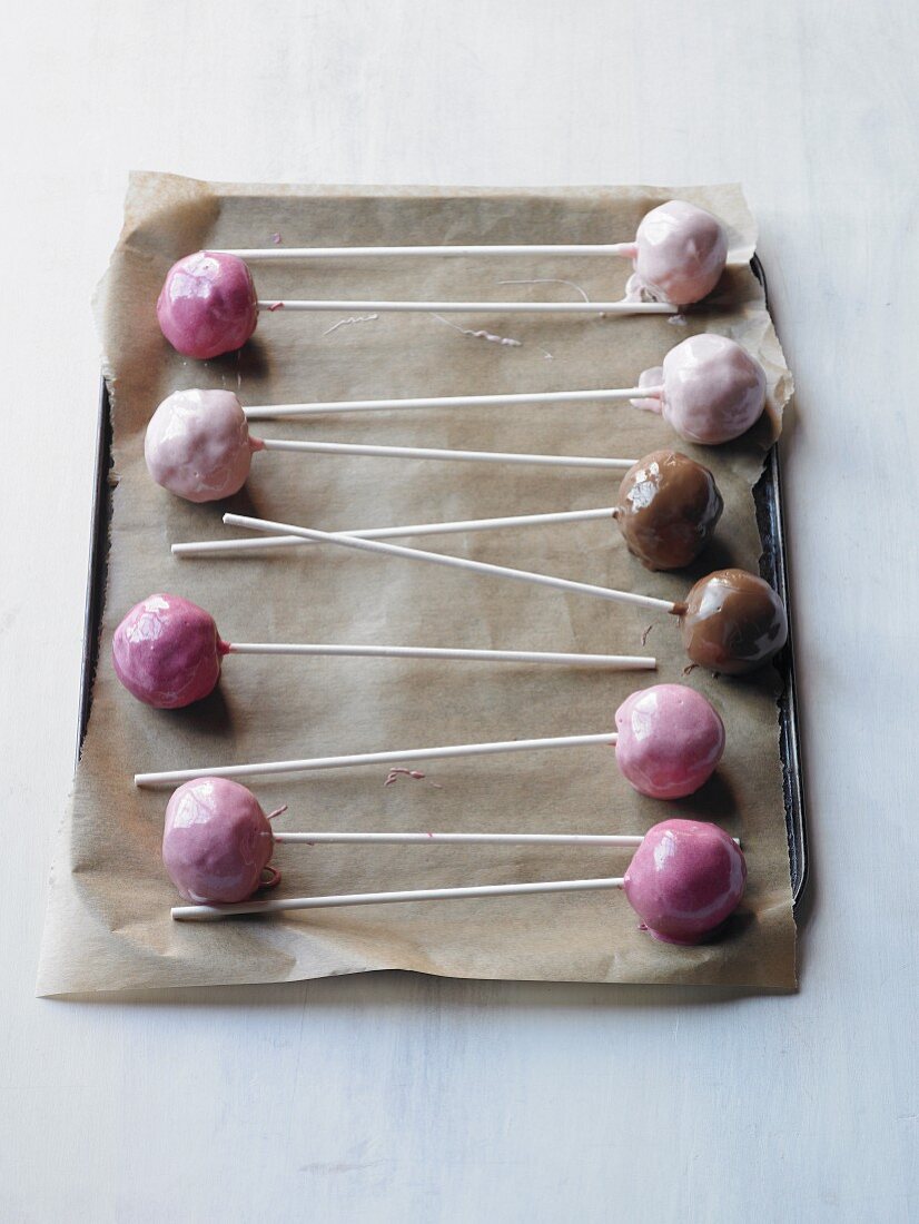 Glazed cake pops on a baking tray