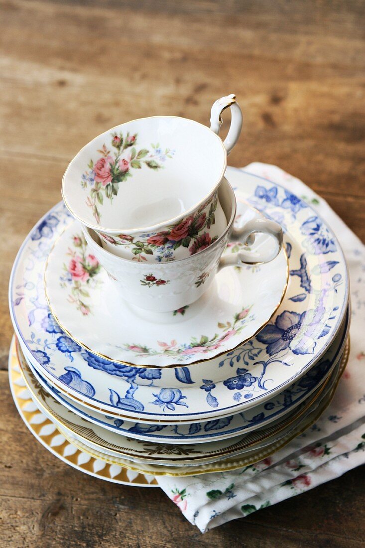 Stacked, vintage china teacups, saucers and plates