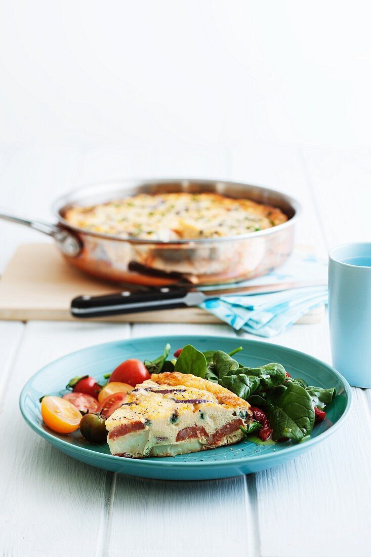 Frittata with potatoes and chorizo in a pan and on a plate