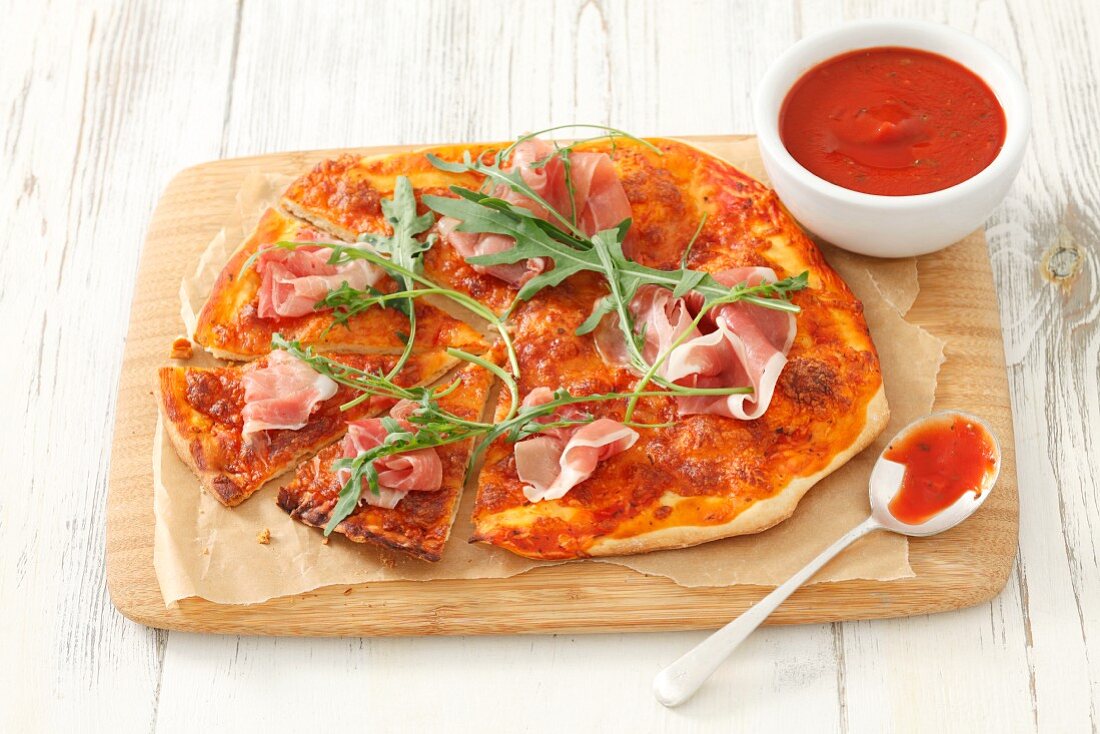 Pizza with dry-cured ham and rocket