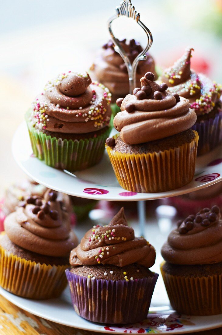 Chocolate cupcakes with sugar pearls on a tiered cake stand