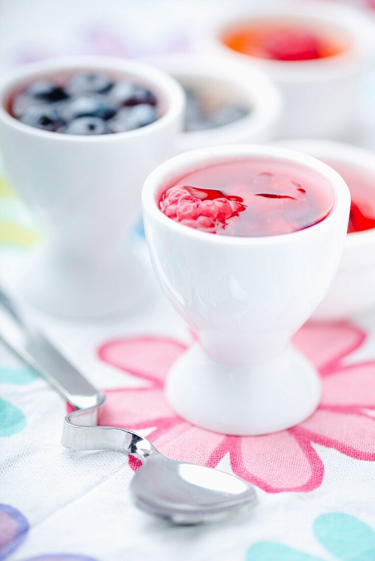 Several mini fruit jellies in eggcups