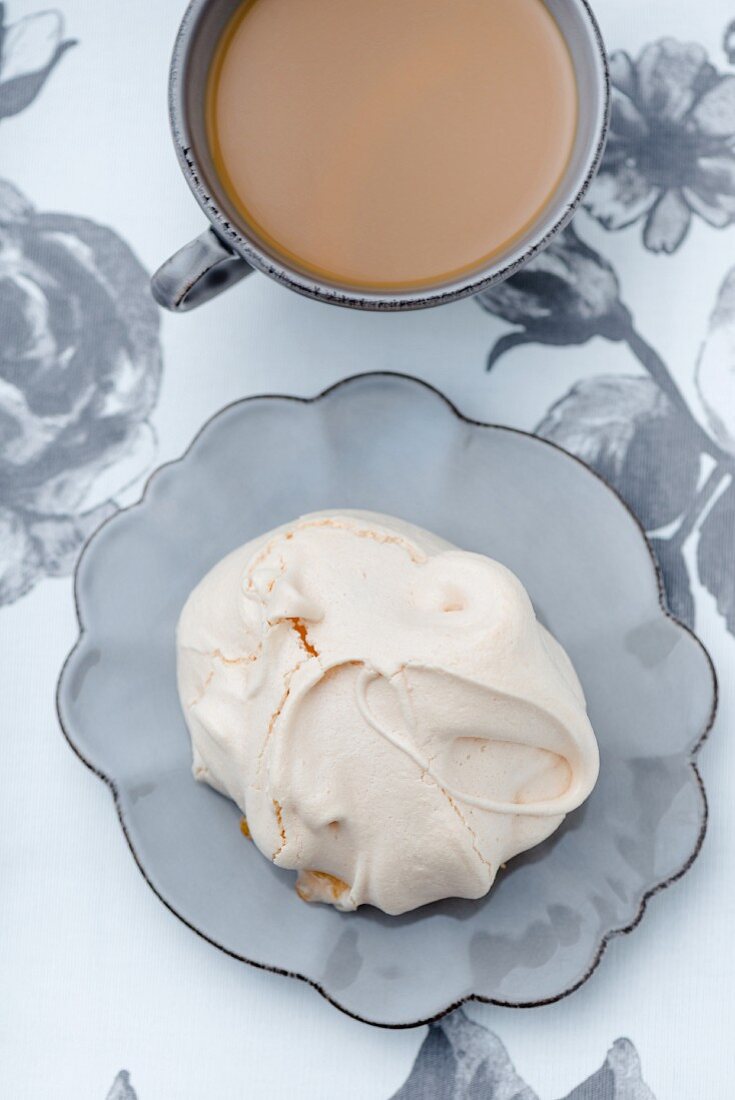 A meringue bite with a cup of coffee
