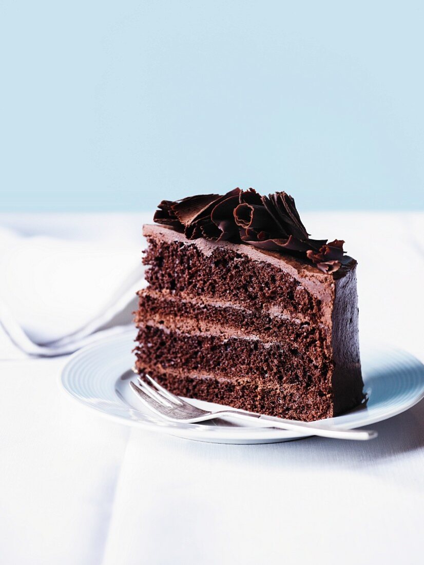 A slices of chocolate mousse layer cake with chocolate curls
