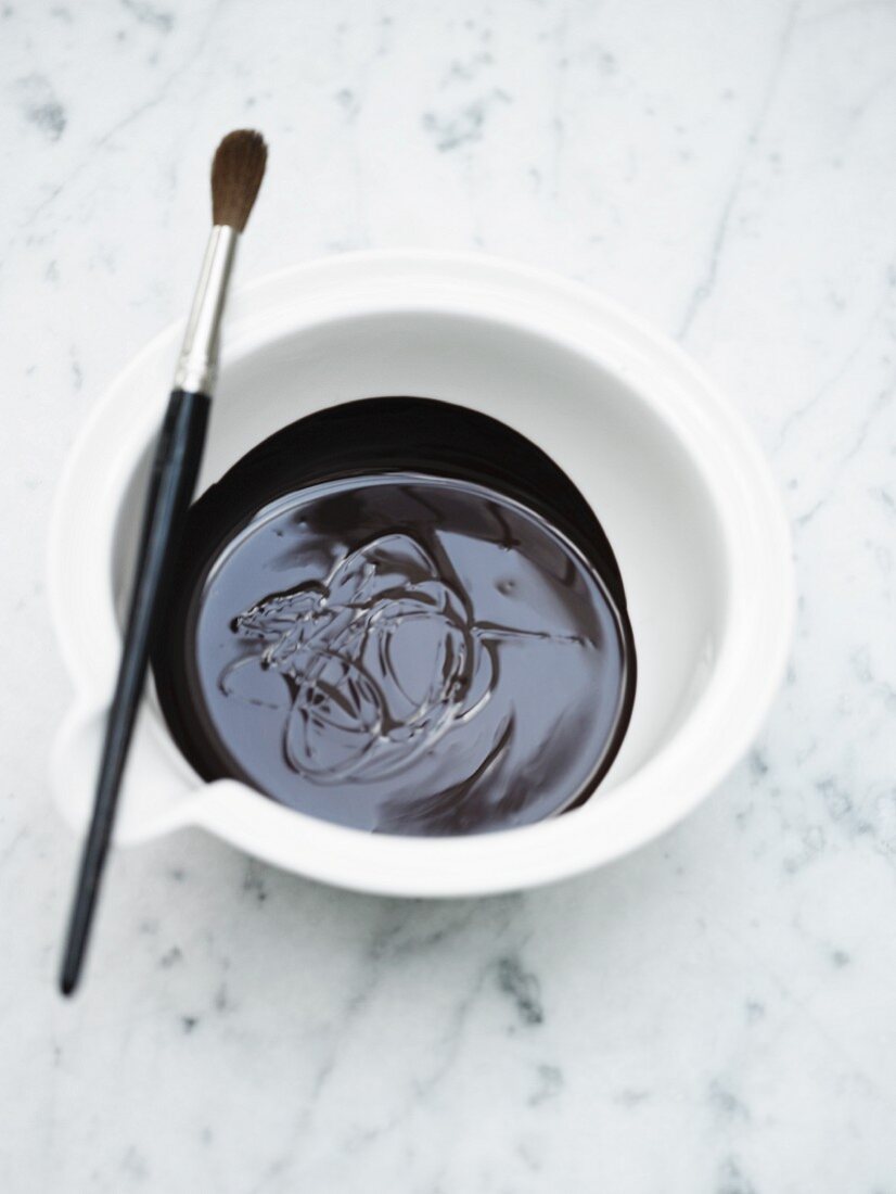 Melted chocolate in a bowl with a paintbrush