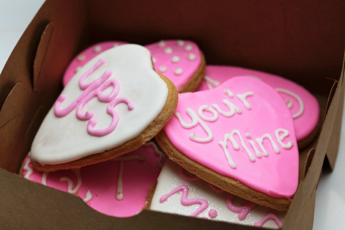 Small gingerbread hearts decorated with white and pink glacé icing