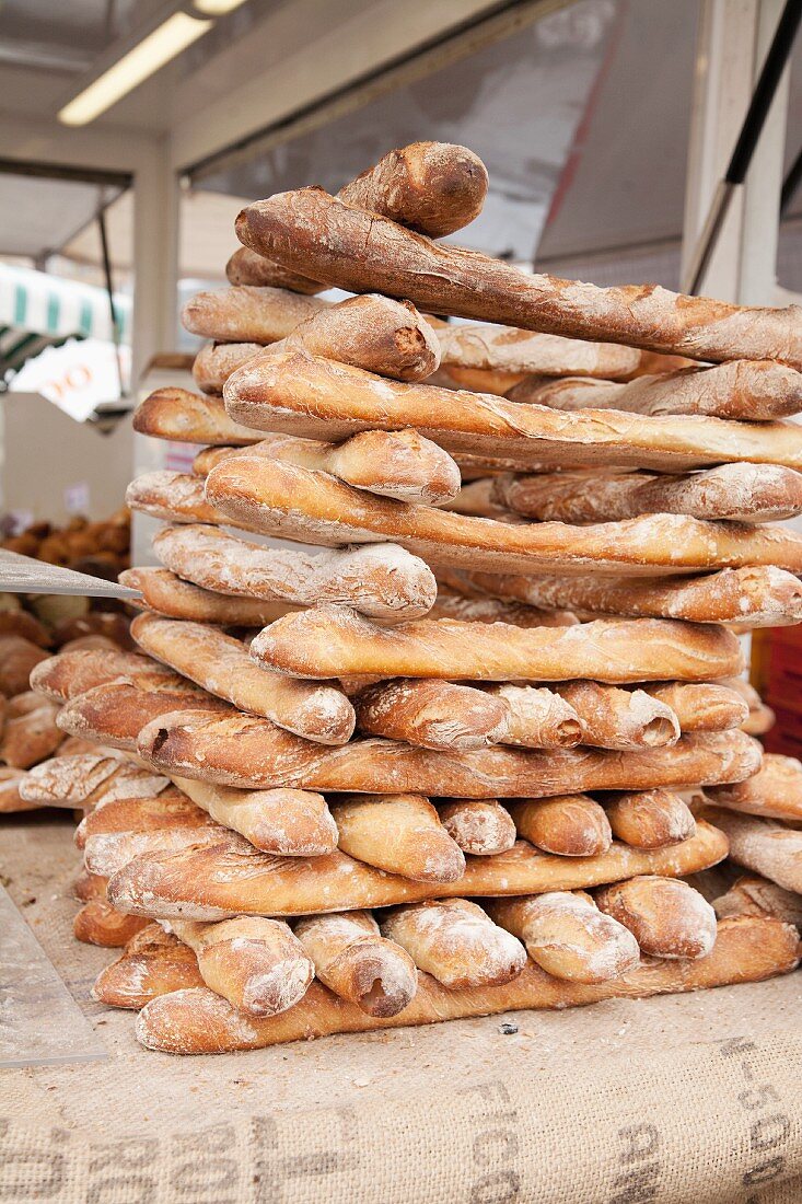 Freshly baked baguettes, stacked, in a bakery