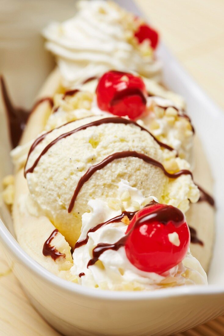 Banana split with vanilla ice cream, banana, chocolate sauce, cream and cherries