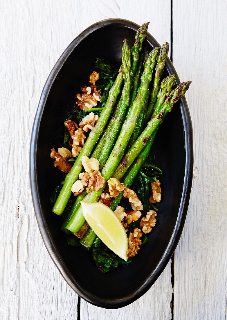 Fried green asparagus with spinach and walnuts