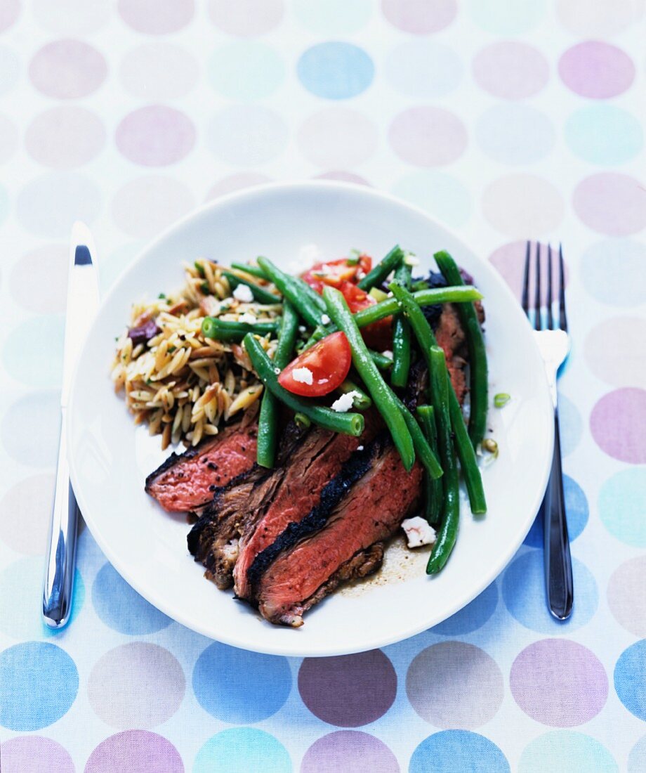 Gegrillte aufgeschnittene Lammkeule mit Bohnen-Feta-Salat und gerösteten Orzo