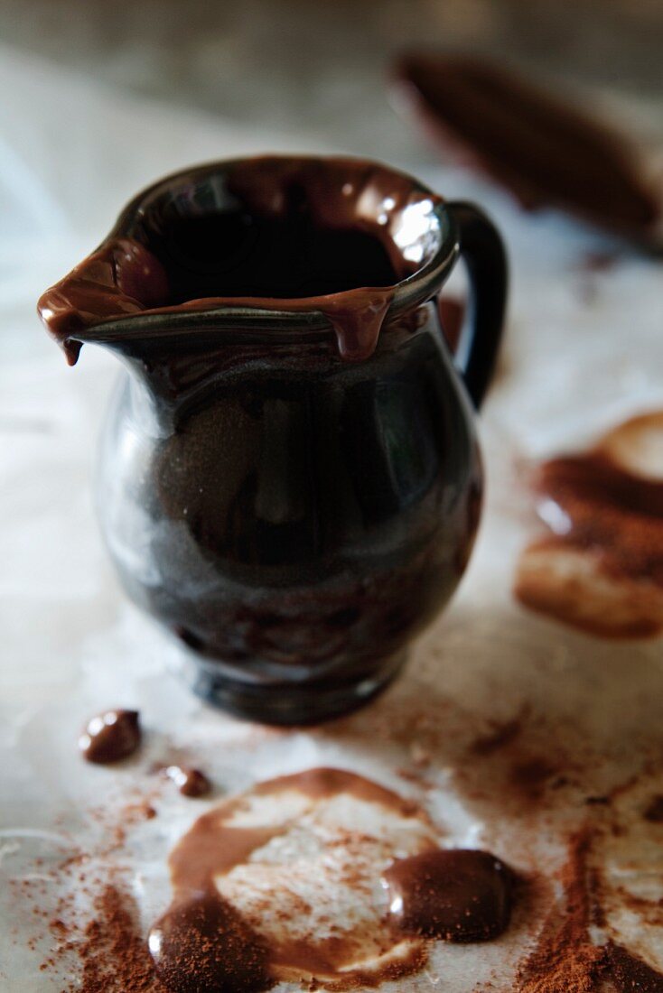 Dunkles Keramikkännchen mit Resten flüssiger Schokolade