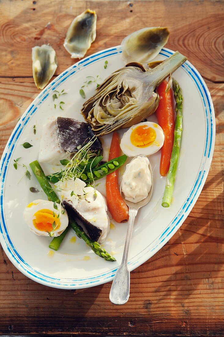 Provencal appetiser featuring artichokes, poached cod, vegetables, eggs and aioli