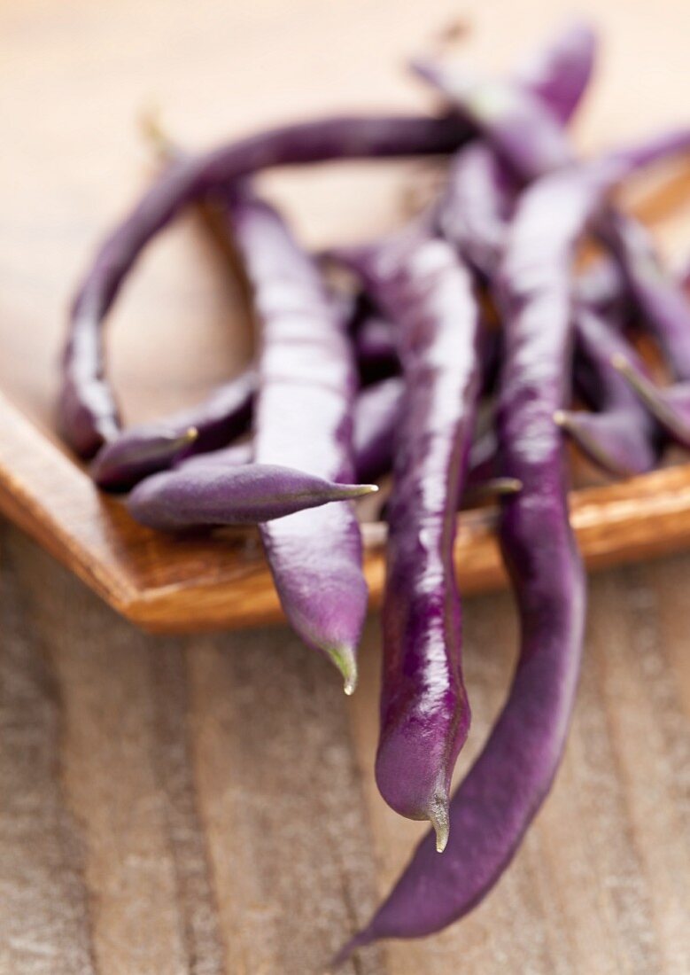 Blue French beans in a wooden dish