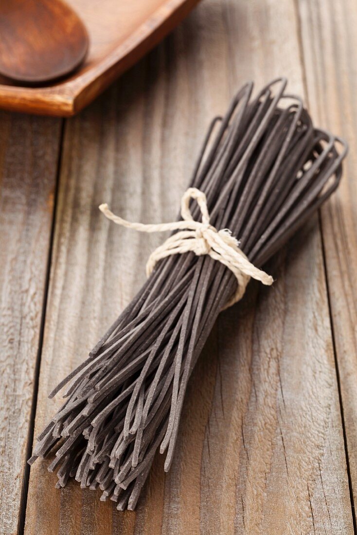 Home-made squid ink pasta, dried and tied in a bundle