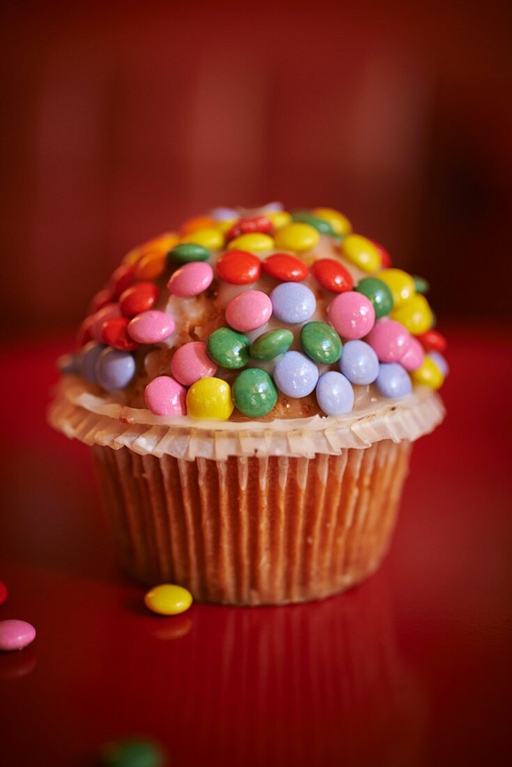 A muffin decorated with Smarties