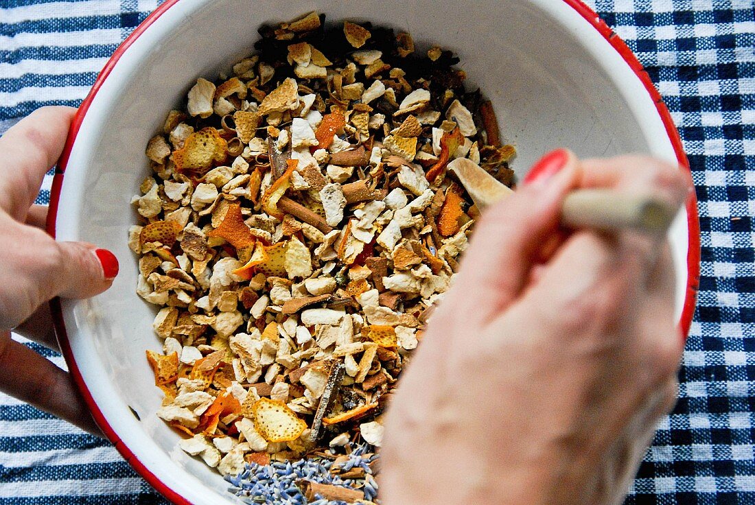 A woman mixing spices for mulled wine in a bowl