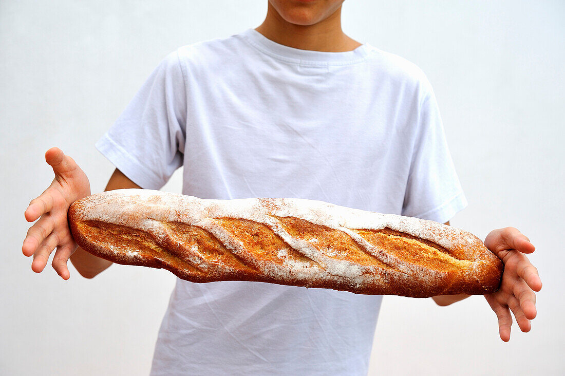 A boy holding a baguette