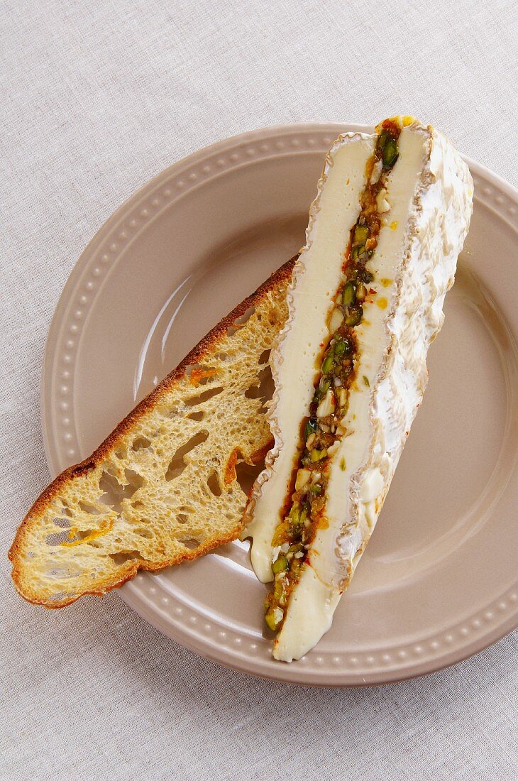 Gefüllter Brie mit Trockenfrüchten auf einer Röstbrotscheibe