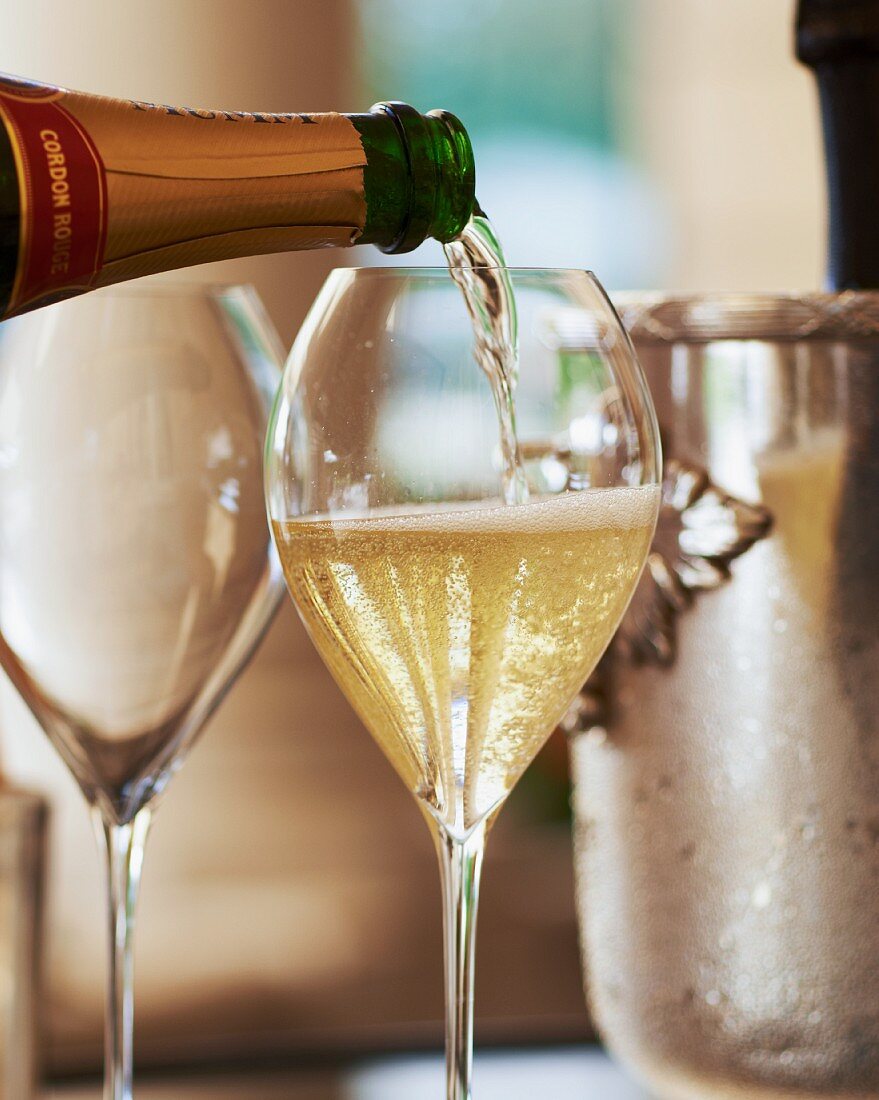Champagner in ein Glas einschenken