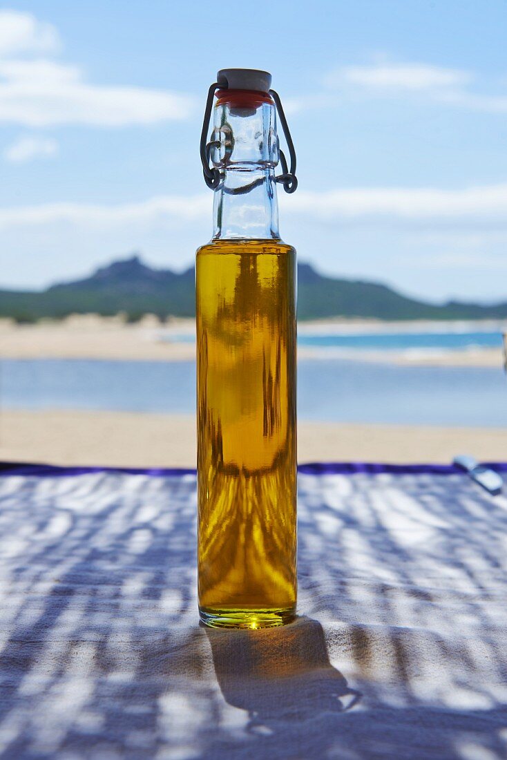 Eine Flasche Olivenöl am Strand