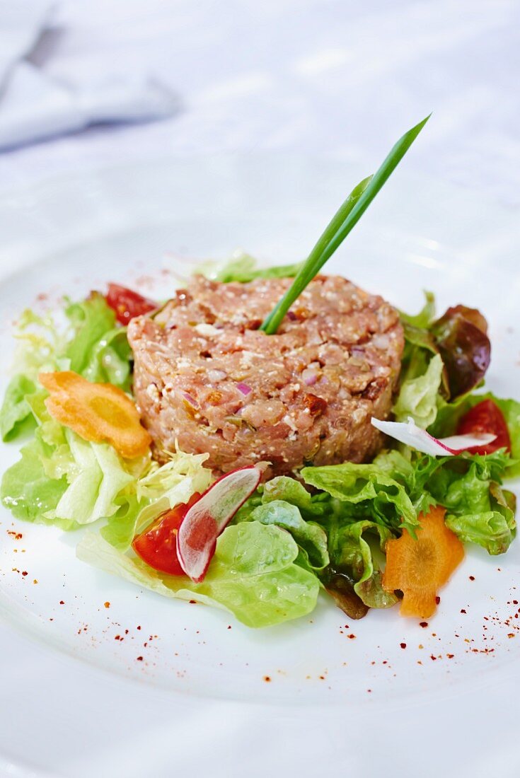 Veal tartare in a ring of salad