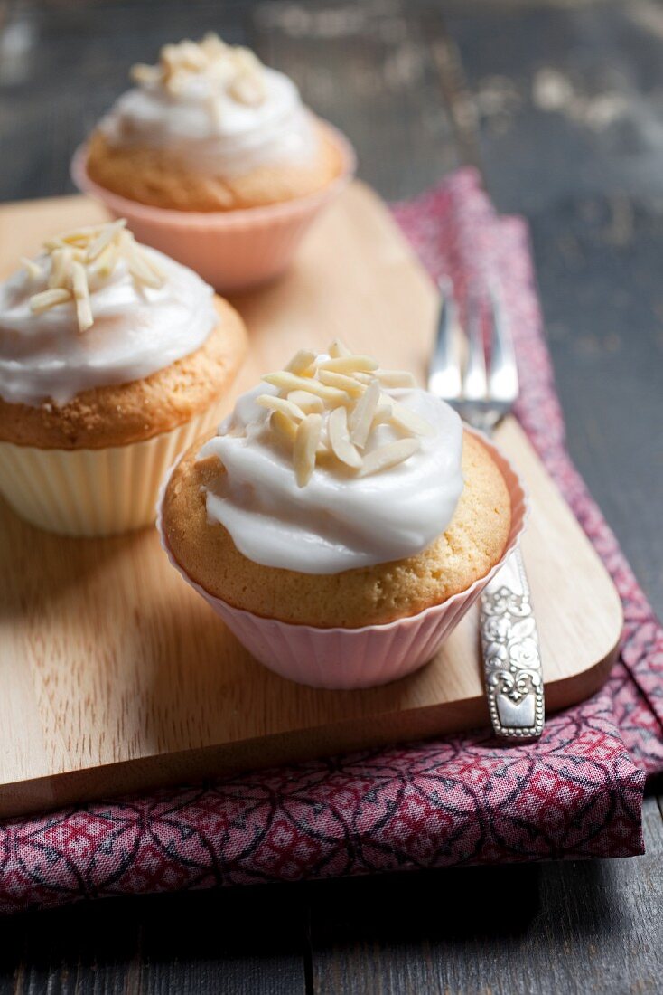 Muffins with glacé icing and nibbed almonds