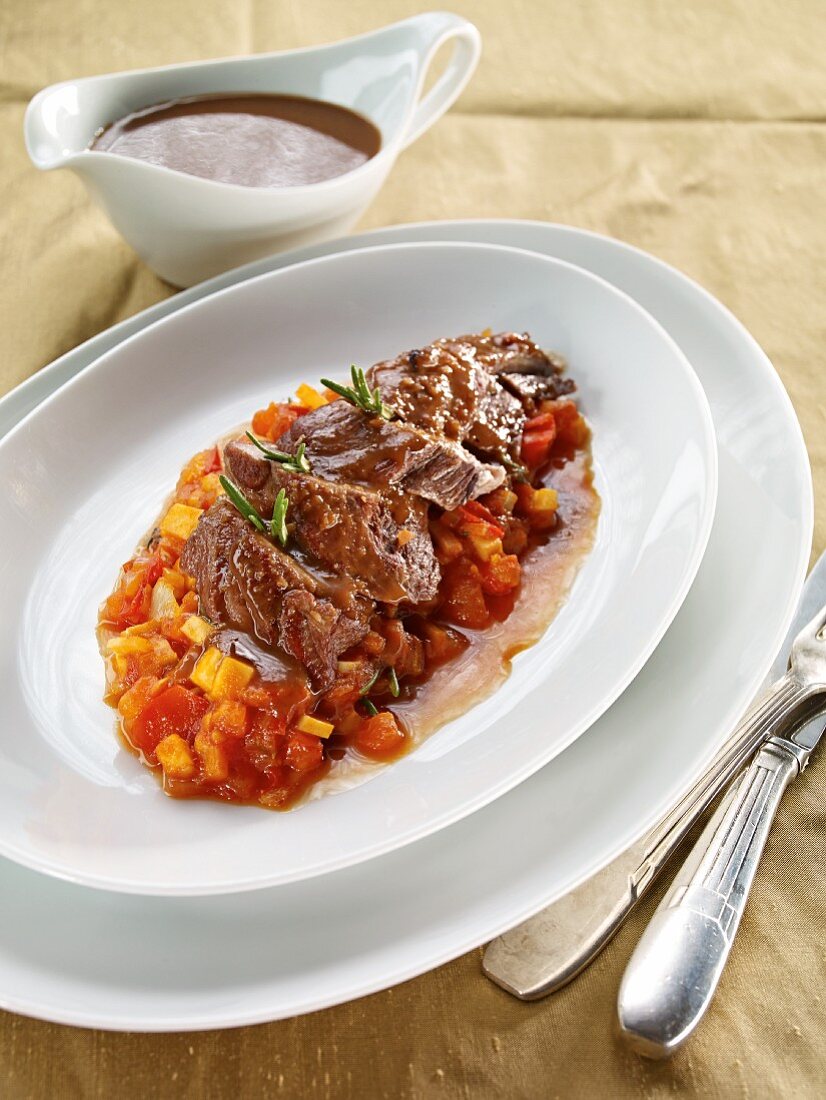 Pot-roasted shoulder of lamb with carrots and peppers