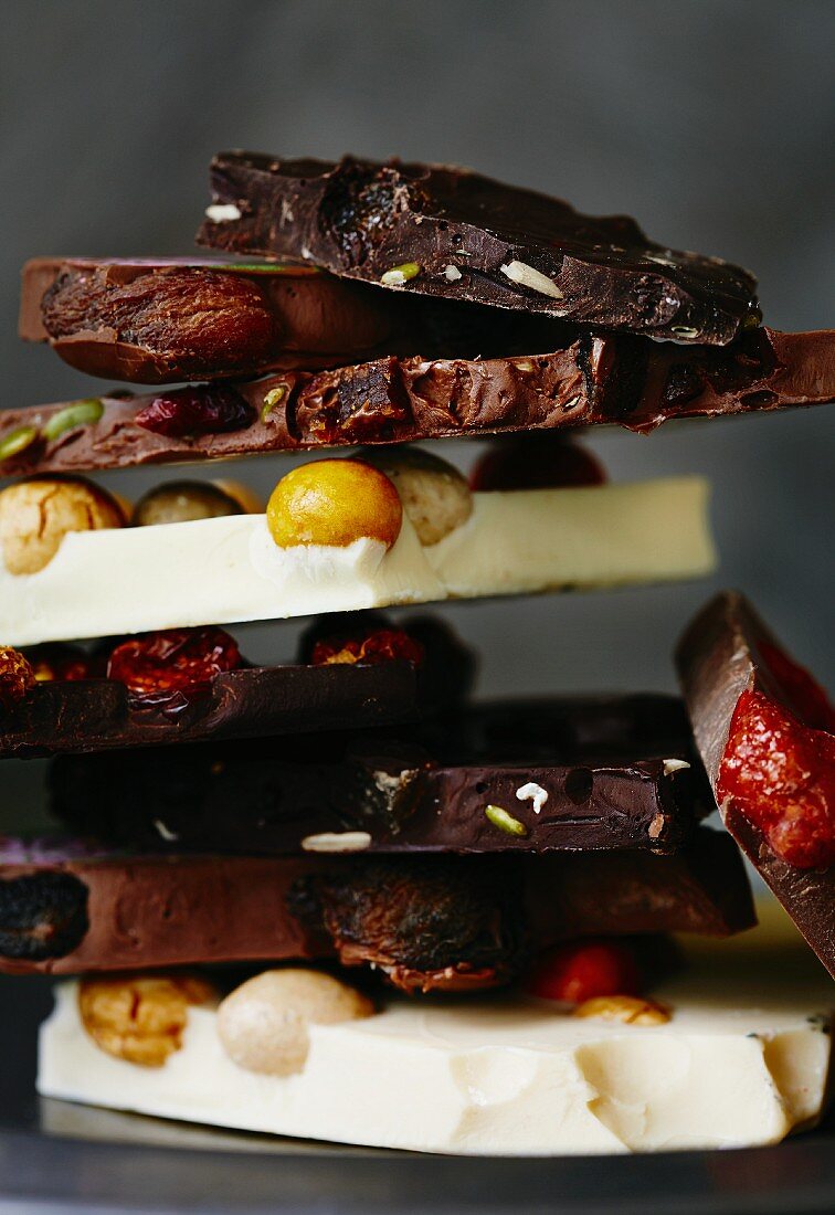 Assorted chunks of broken chocolate, stacked (close-up)