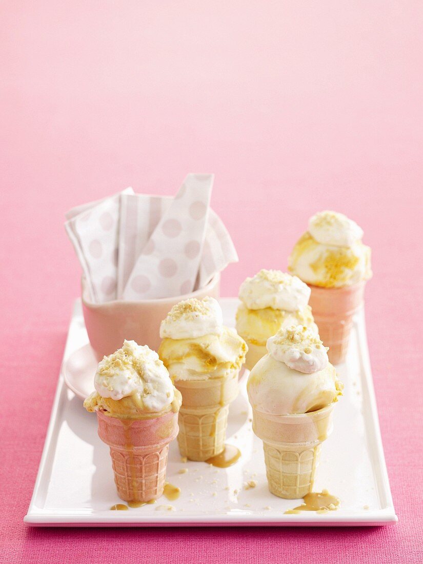 Vanilla & toffee ice cream with creamy peanut topping in multicoloured cones