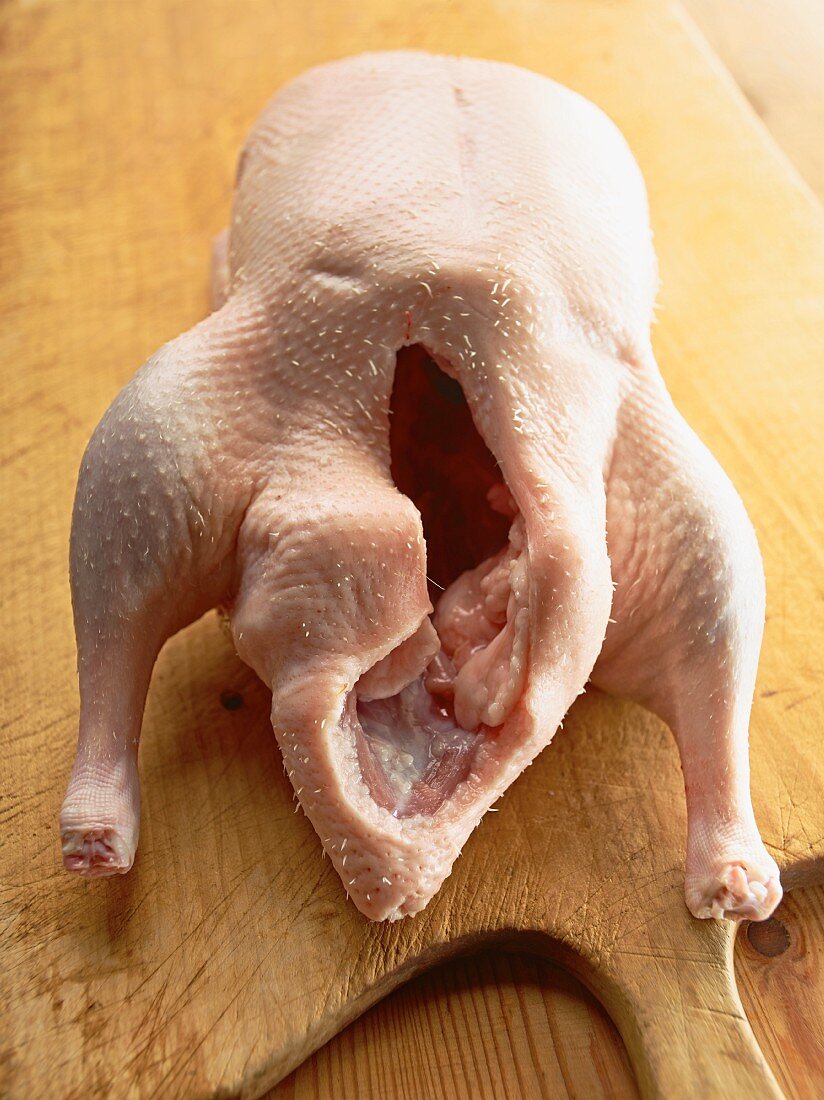 A raw goose on a chopping board