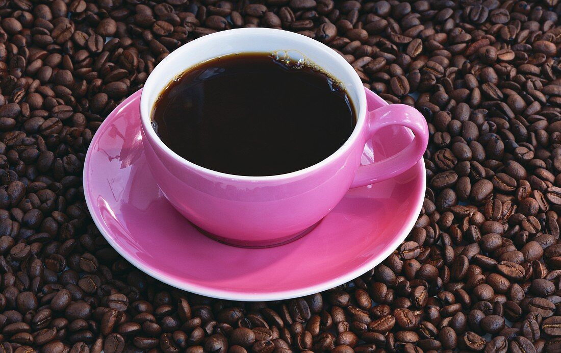 Eine Kaffeetasse auf Kaffeebohnen