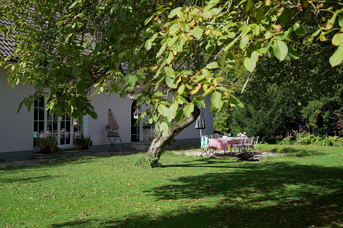 Sonnenbeschienenes Terrassenplatz mit französischen Metallmöbeln im Garten