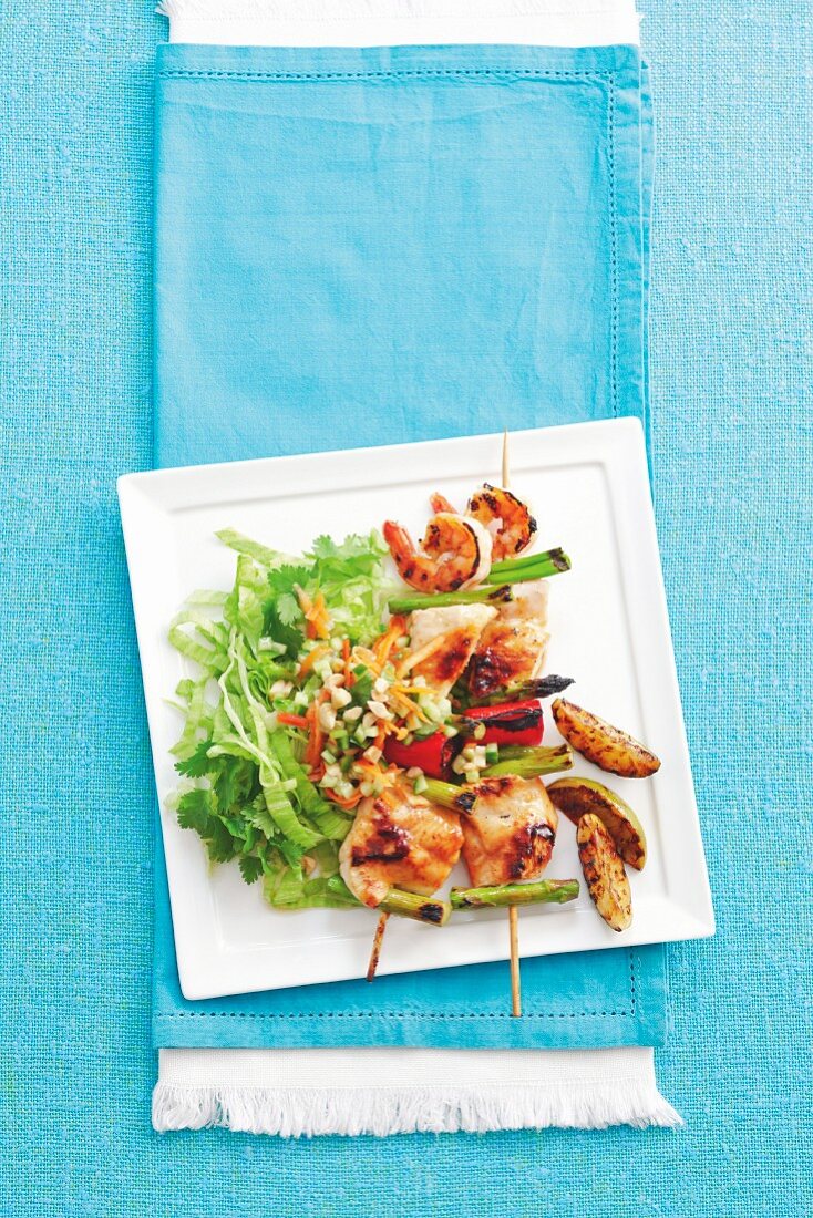 Fish skewers with prawns and vegetables, served with an Asian carrot salad