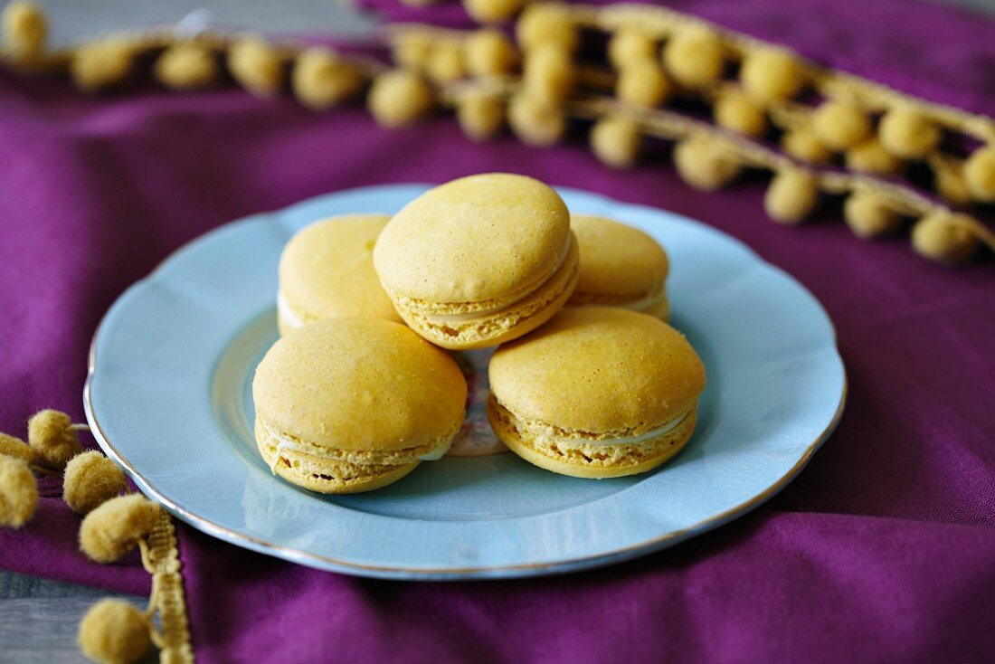 Zitronen-Macarons auf hellblauem Teller