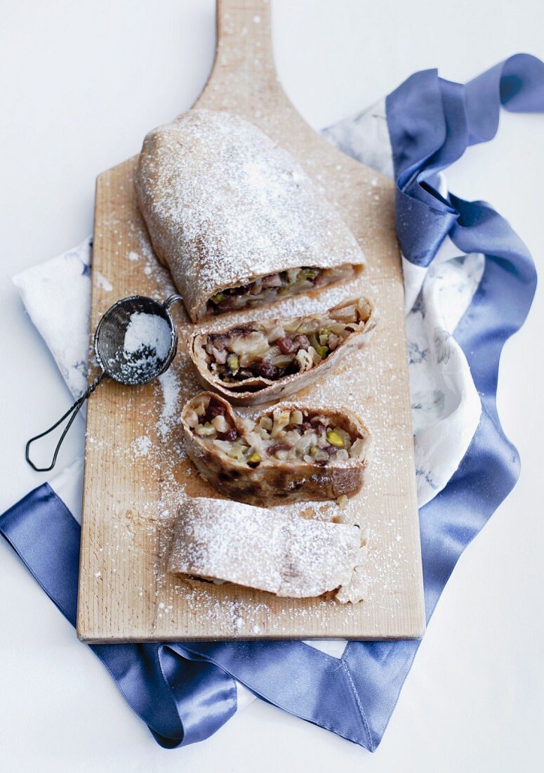 Apple strudel with icing sugar on a chopping board