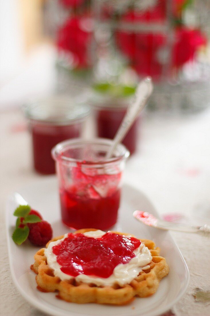 A waffle topped with raspberry and rose jam