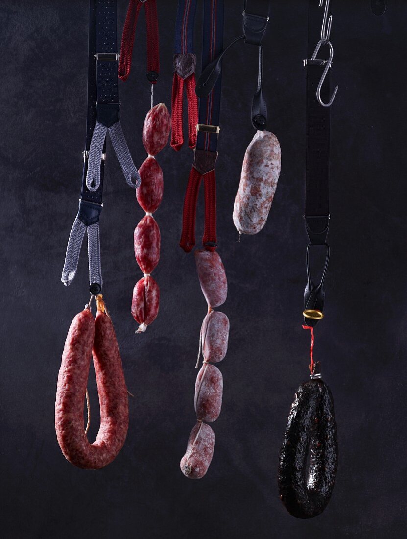 Assorted sausages hanging on braces