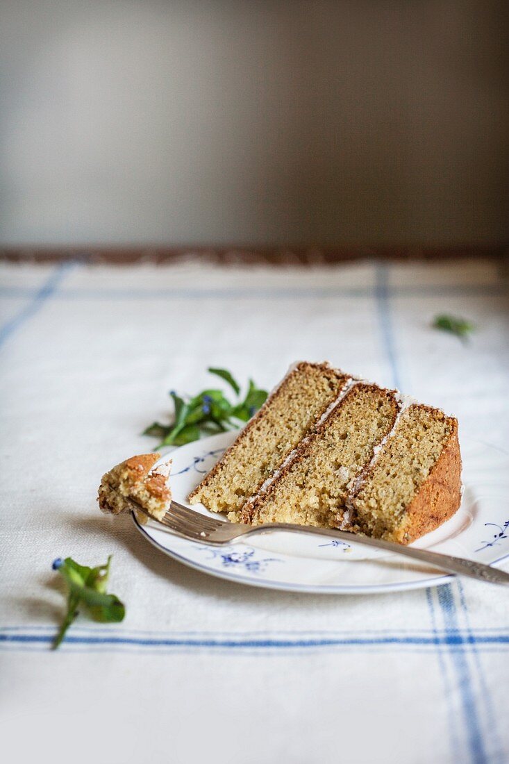 Ein Stück Rosmarin-Polenta-Kuchen mit Honig-Butter-Creme