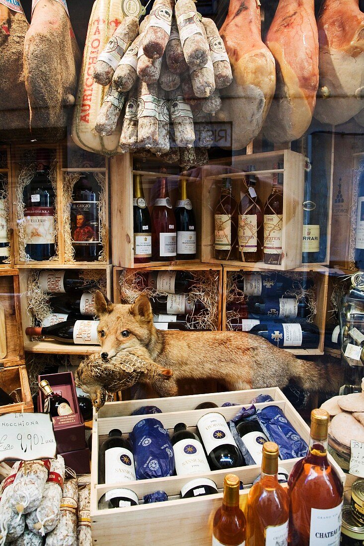 Wine and meat in a shop window, Italy.