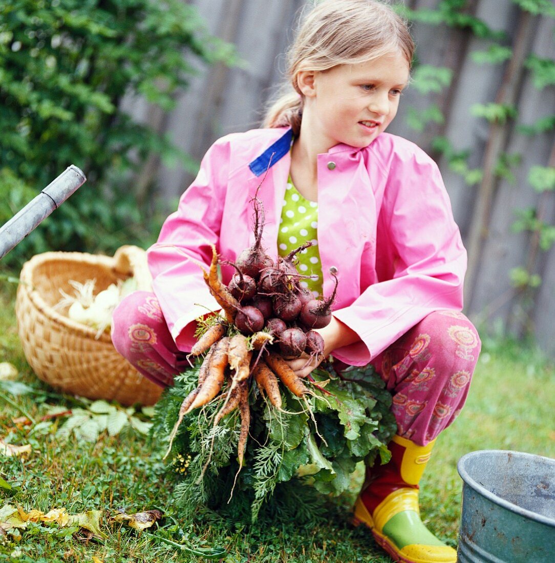 A girl holding carrots, Sweden.