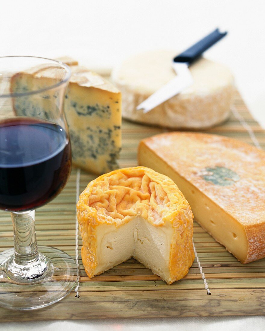 A still life of cheese and red wine