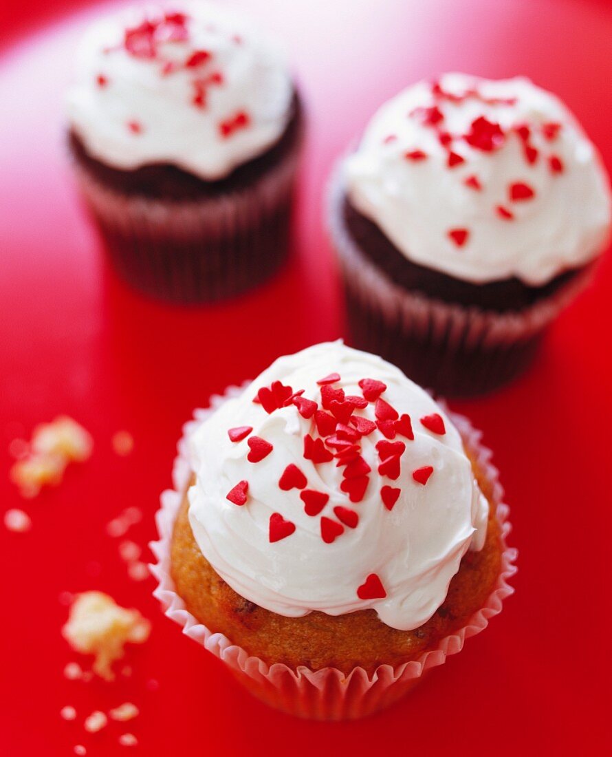 Cupcakes mit Sahnecreme und roten Herz-Streuseln