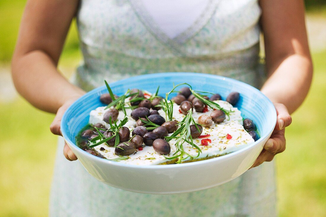 Woman with a bowl of feta and olives, Sweden.