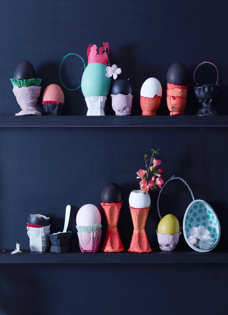 Eier in dekorativen Eierbechern auf Regalbrettern
