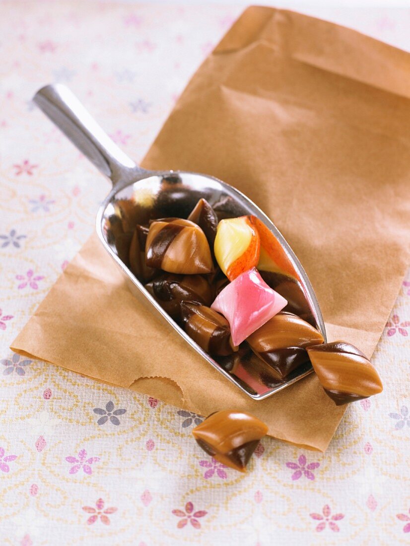 Schokoladen- und Karamellbonbons auf Metallschaufel