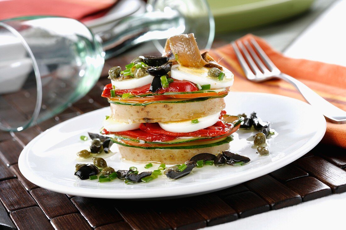 A vegetable tower with anchovies, egg and an olive and caper sauce