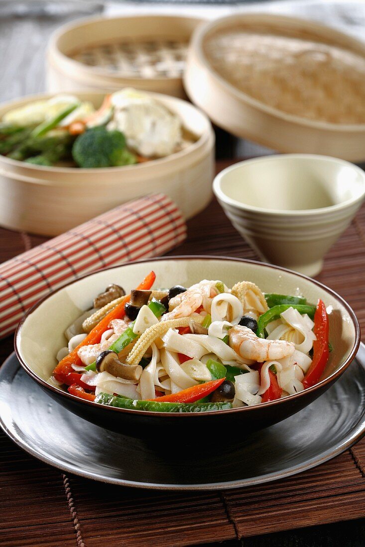 Wide oriental noodles with vegetables and prawns